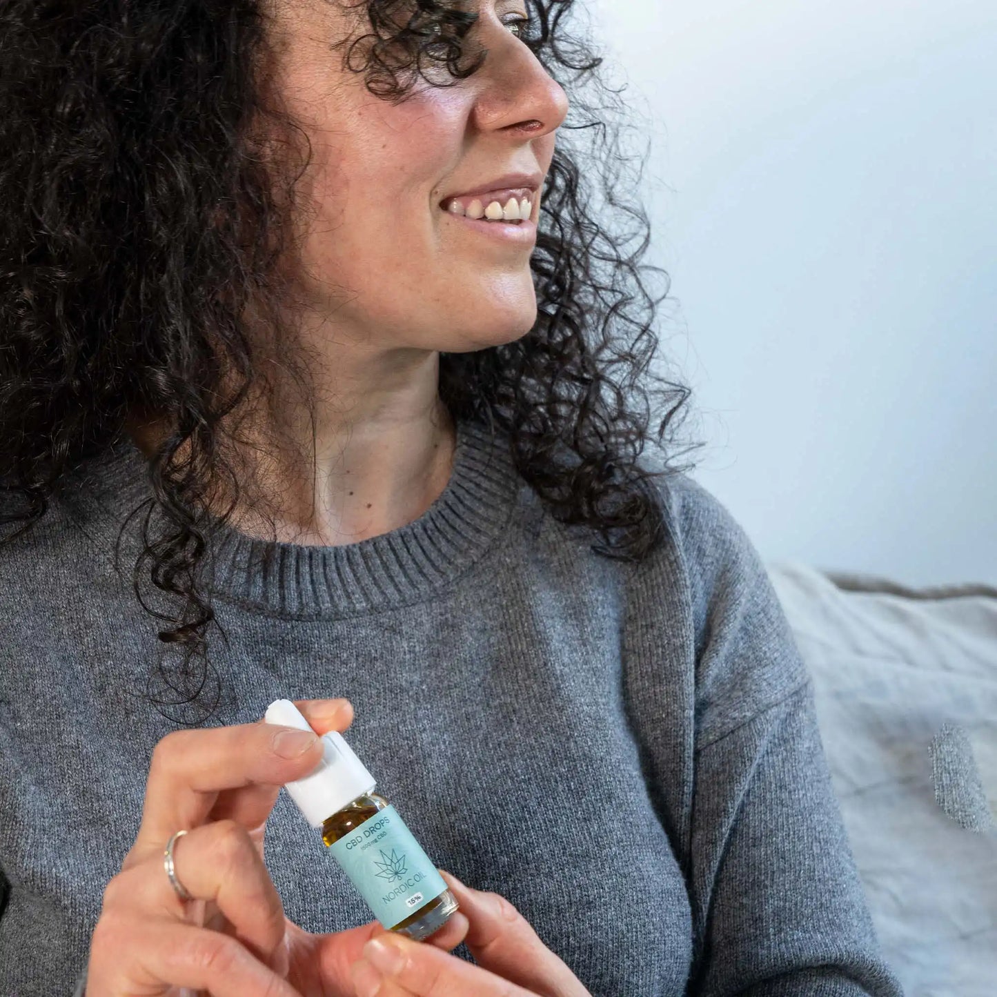 Eine Frau hält eine Flasche 15% CBD Öl Plus von Nordic Oil