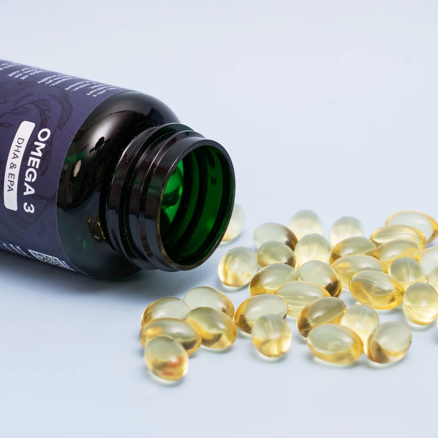 offener und liegender Omega-3 Behälter von Nordic Oil mit liegenden Omega-3 Kapseln daneben