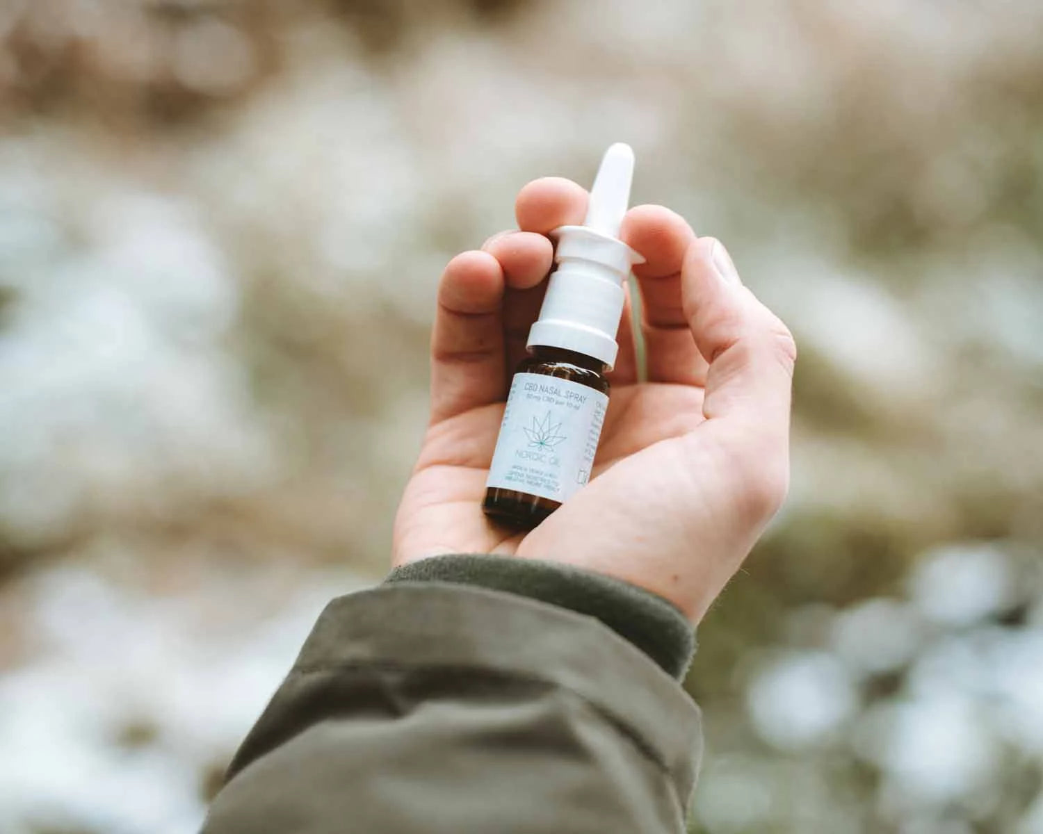 Eine Hand hält das Nordic Oil CBD Nasenspray