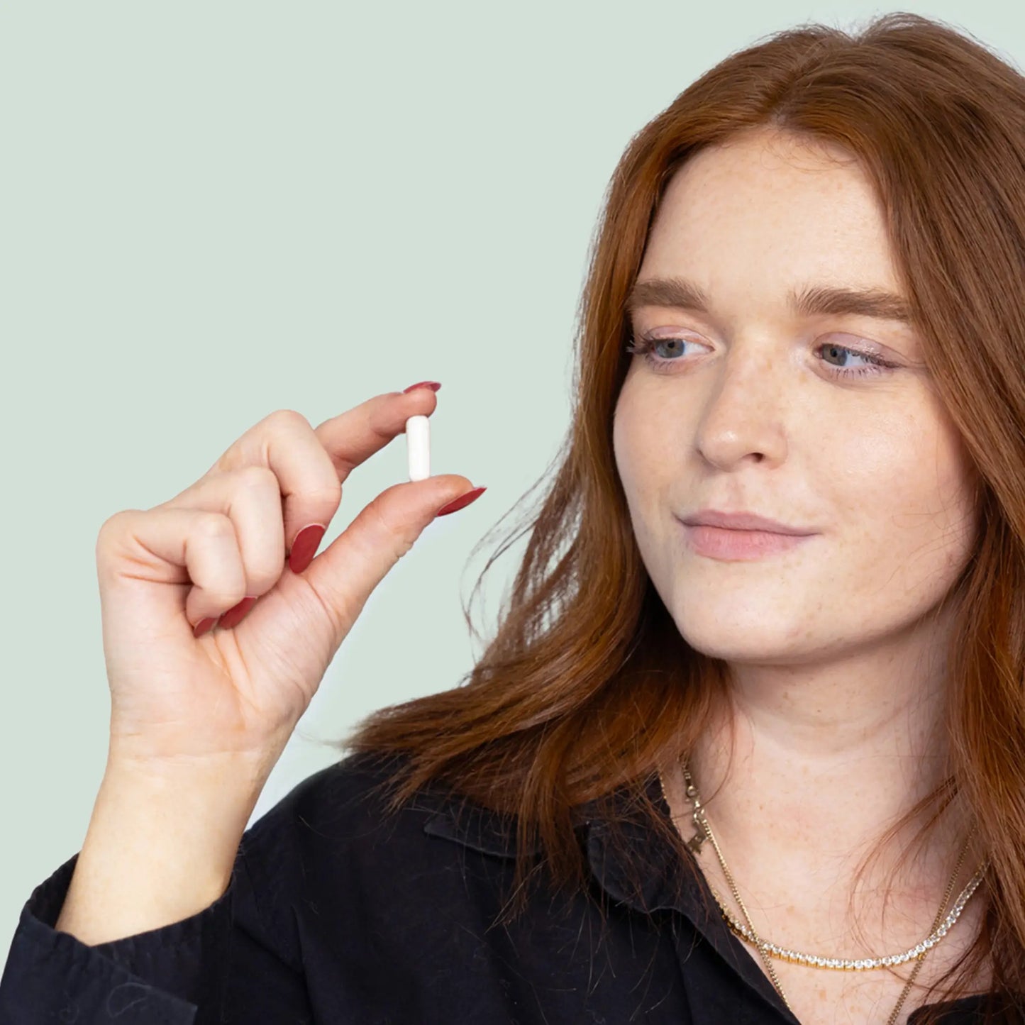 Frau hält Magnesium Kapsel