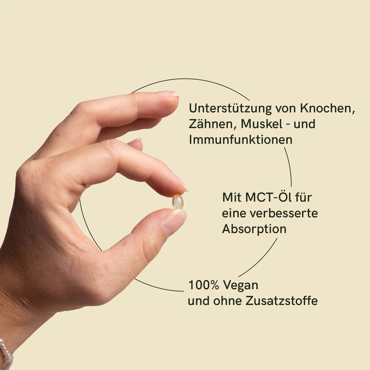 Hand hält Softgel mit Text: Unterstützung von Knochen, Zähnen, Muskel- und Immunfunktion; Mit MCT-Öl für eine verbesserte Absorption; 100% vegan und ohne Zusatzstoffe