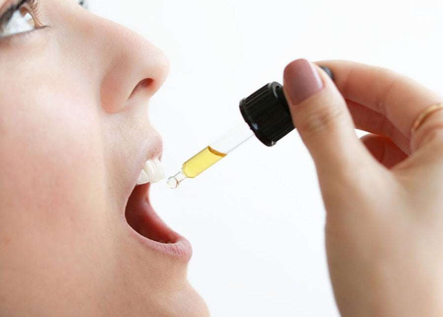Eine Frau Tropft sich CBD Öl in den Mund 