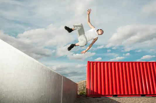Person springt von Haus zu Haus