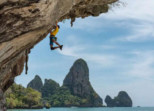 Mann klettert Felsen hoch