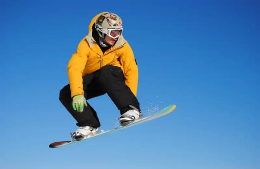 Person tut Snowboarden in der Luft