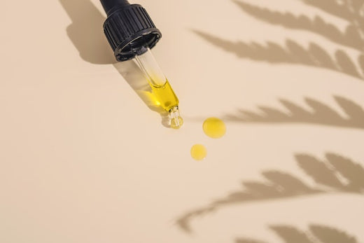 Eine Pipette mit CBD Öl liegt auf einem Braunen Hintergrund.