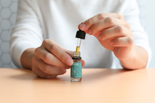 Ein Mann öffnet eine Flasche des CBD Öl (5%)