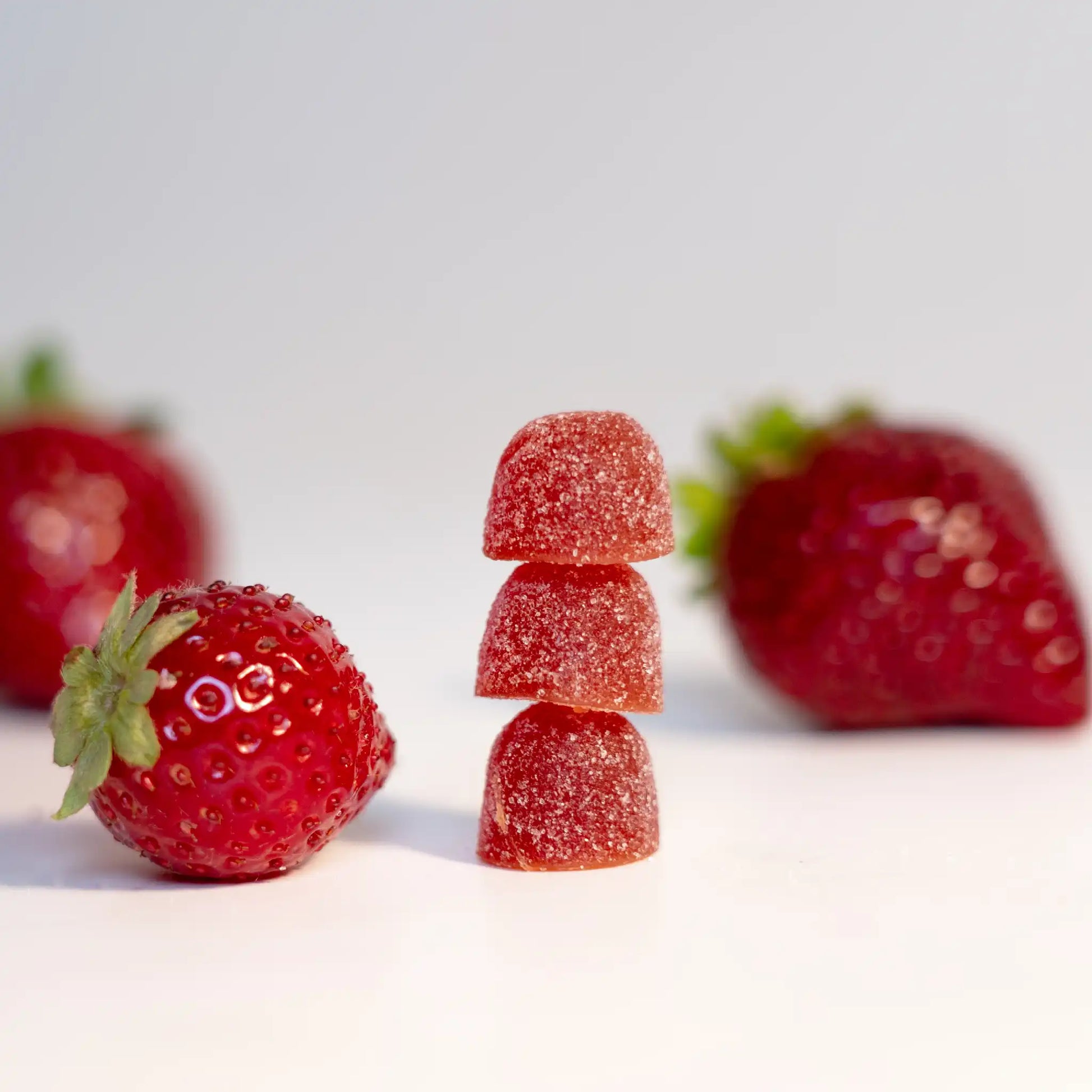 Drei CBD Fruchtgummies mit Erdbeeren