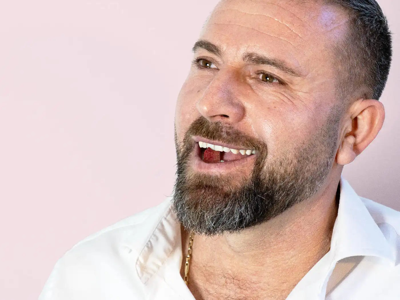 Ein Mann hat ein CBD Fruchtgummi (Erdbeere) im Mund