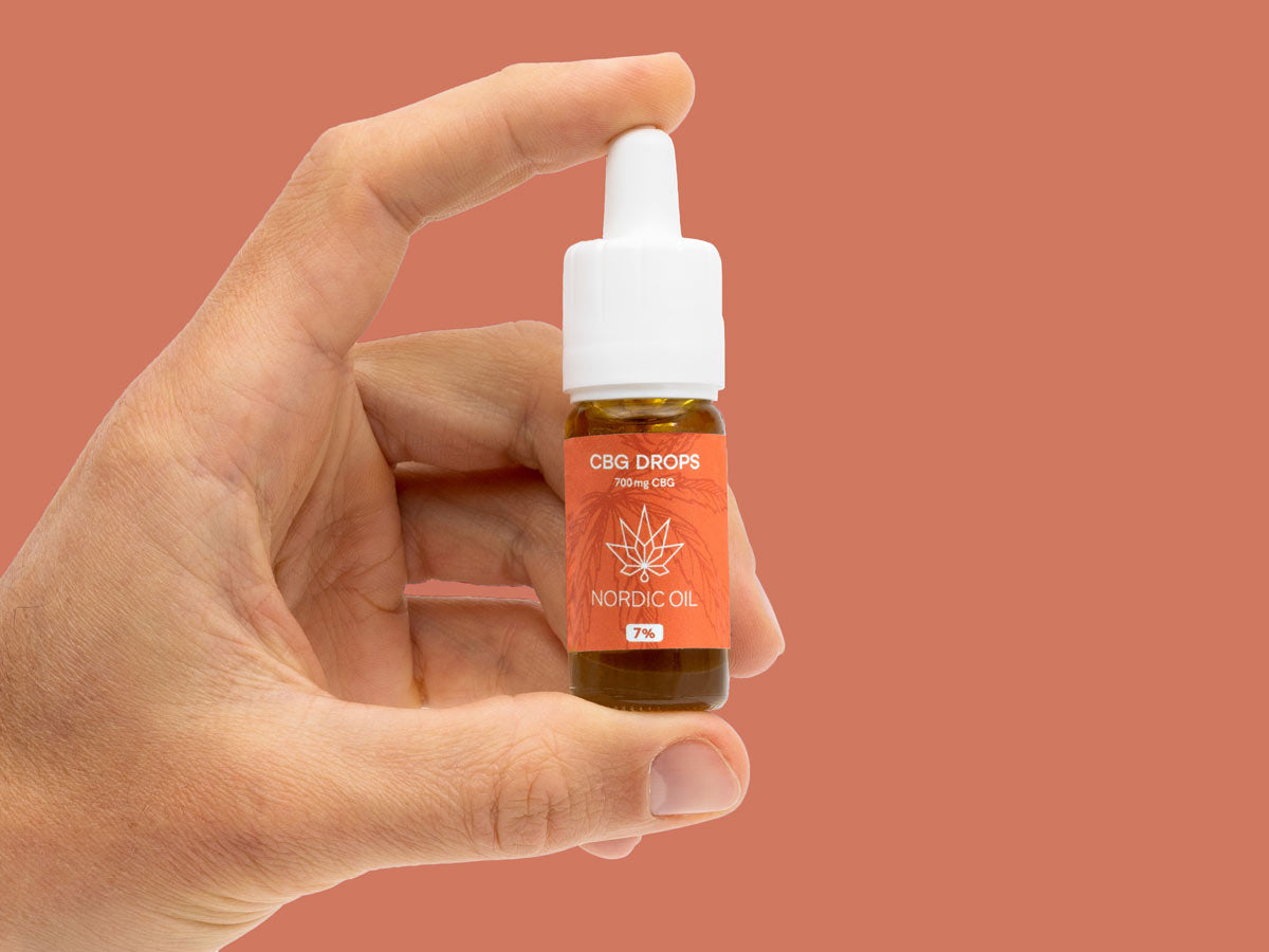 Hand hält Flasche mit CBG Tropfen (7%)