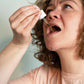 Eine Frau tropft sich CBG Öl unter die Zunge